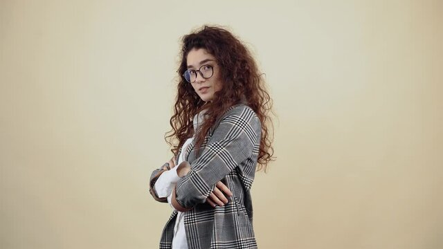 A confident and strong woman with her hands in the middle, she inspires confidence by looking into the room as she moves in profile. Cretaceous in gray jacket and white shirt, with glasses posing