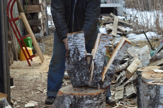 Man Splitting Birch Log With An Axe