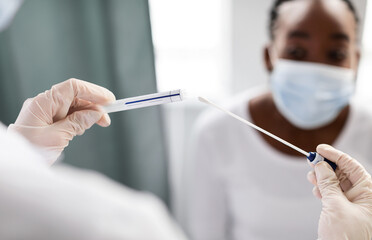 Doctor taking PCR test sample from potentially infected afro woman