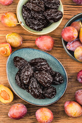 Fresh  prune and dried  prune on wooden board background