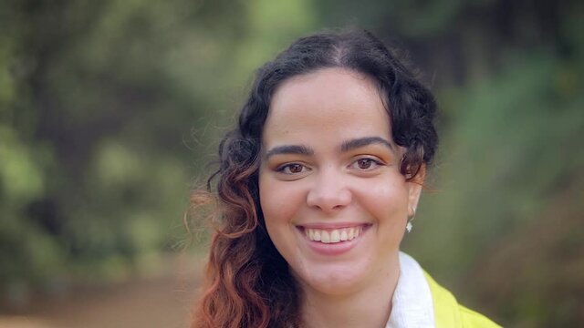 mujer joven pelirroja sonriendo en un camino en el bosque verde cubierto por &aacute;rboles en Espa&ntilde;a