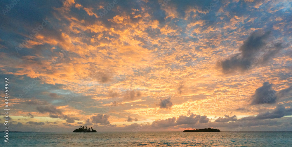 Wall mural sunrise with dramatic clouds on the tropical beach. panorama with two uninhabited tropical islands