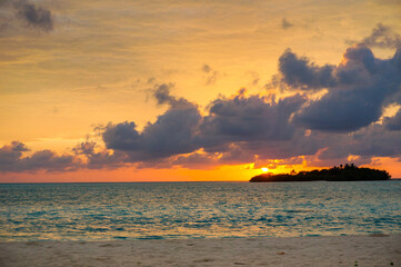 Sunrise with dramatic clouds on the tropical beach. Panorama with two uninhabited tropical islands