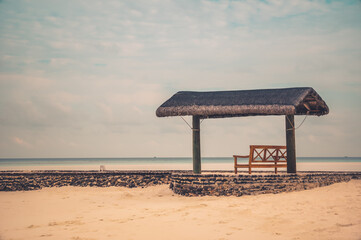 Fototapeta na wymiar isolated bench on a tropical beach looking at the horizon. 