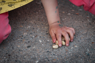 Child holding pistachios and playing with them
