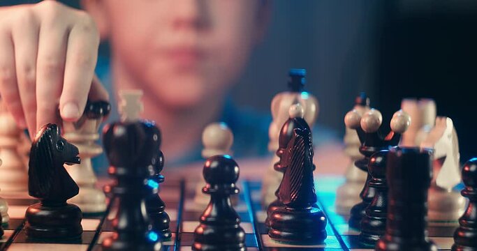 Cute little boy playing chess at home. Smart kids. Game good for brain intelligence concept. Clever concentrated and thinking child while playing chess. Kids early development. Figures on chessboard.