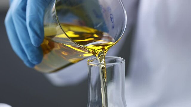 Scientist chemist pouring motor oil into test tube closeup 4k movie