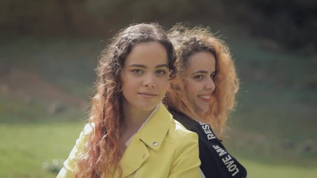 plano en movimiento de Dos hermanas gemelas de espaldas, con el fondo en movimiento 
