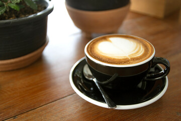 Coffee in cup on wooden table in cafe
