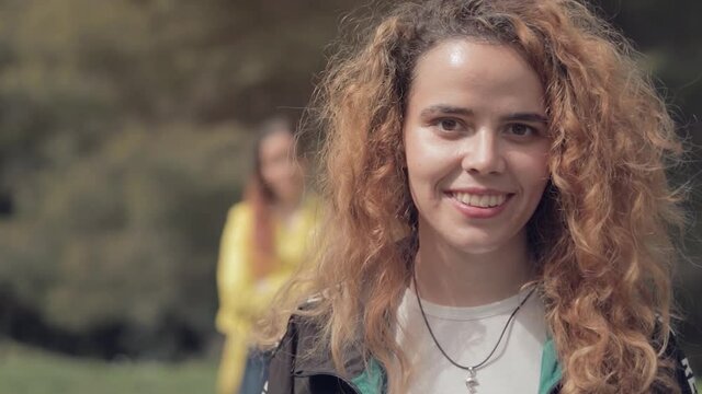 Dos hermanas gemelas, una aparece detr&aacute;s de la otra, en un bosque al sol