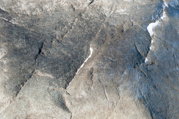 Background, texture. The enlarged surface of a large stone with cracks.