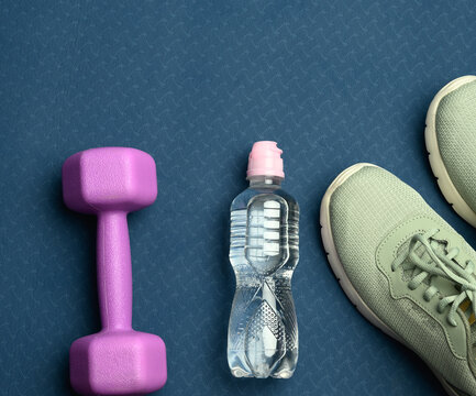 Pair Of Green Sports Sneakers And A Bottle With Mineral Water