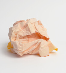 crumpled ball of yellow paper on white background