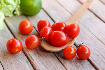 .Red fresh tomatoes on wooden spoon