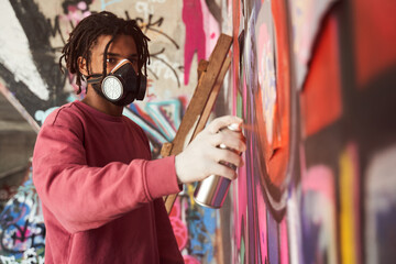Street artist painting colored graffiti