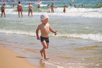 child swims in the sea waves on the beach