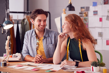 Fototapeta premium Male And Female Students Or Business Owners Working On Designs In Fashion Studio Together