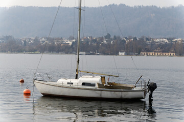 old interesting boat with black outboard motor floats leaderless on the water, the anchor was laid