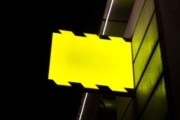 Editable PSD mockup with hanging outdoor glowing sign board at night.