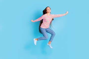 Fototapeta na wymiar Full length body photo girl jumping cheerful happy wearing casual clothes isolated vivid blue color background