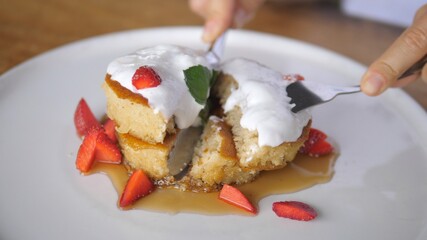 Cutting pancake tower decorated with cream and fresh berries. Sugar free plant-based dessert for breakfast