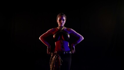 exotic dancer woman is performing oriental dance in dark studio, moving her beautiful body