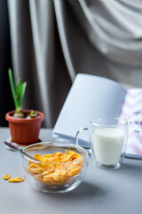 Morning healthy breakfast variety concept. glass bowl of milk next to cornflakes in a glass on a grey background. Top view. Healthy eating.