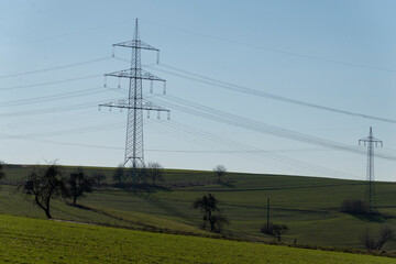 Strommasten auf gr&uuml;nem Feld
