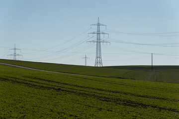 Strommasten auf grünem Feld
