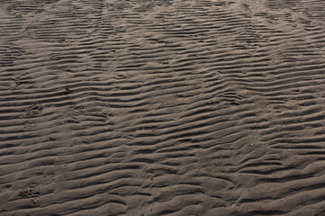 Wavy pattern of sand on a beach.