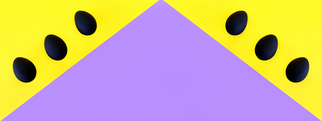 Black eggs on the yellow and violet background. Easter, diversity, geometric, pattern, food concept