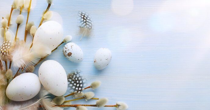 Flat lay Easter composition with a willow branch and eggs on a blue background