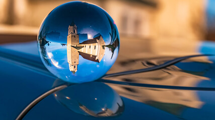 Fototapeta na wymiar Crystal ball landscape shot with reflections on a car roof at Aholfing, Bavaria, Germany