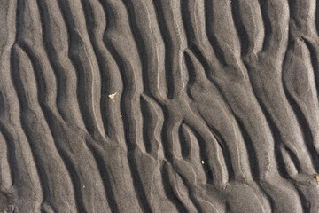 Wavy pattern of sand on a beach.