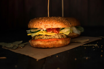 Closeup vegan burger served on dark background in kitchen