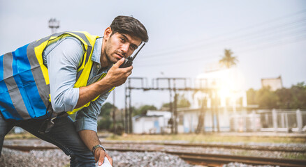 Caucasian man railway engineer use walkie-talkie talking in the site work of train garage.