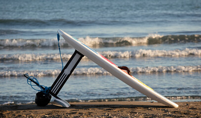 Hydrofoil (foilsurfing) on the beach sand, sea with gentle waves in the background