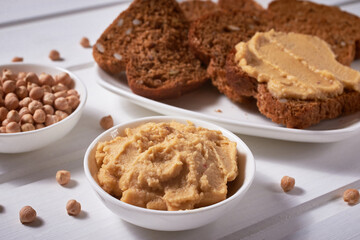 Chickpeas and chickpea dishes-hummus, whole-grain bread with pate on a white wooden background. Healthy eating.