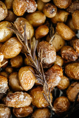 Golden fried or baked potatoes with a sprig of thyme in a frying pan, Macro photo with shallow depth of field.