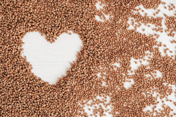 Buckwheat as a heart background texture on a white background. Top view. Copy, empty space for text
