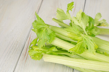 Bunch of fresh celery stalk with leaves on a wooden background
