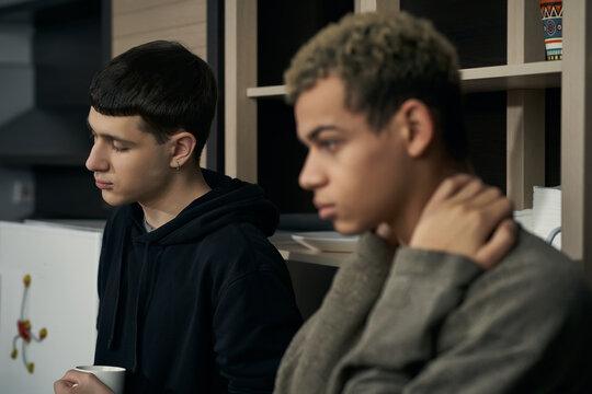 Staged Photo Illustrates Problems And Conflicts In Gay Couple Relationships. Moment Of Showdown In The Kitchen: Two Musing And Upset Men Are Standing Close To Each Other. 