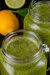 Healthy green smoothie with spinach in glass jars.