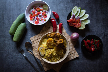 Chicken biryani or traditional rice with salad ingredients and condiments. Top view, selective focus.