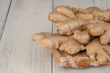 Fresh, light, healthy ginger on white wooden background