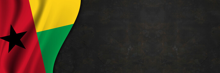 Guinea-Bissau flag on concrete wall. Banner with fabric texture of the flag of Guinea-Bissau