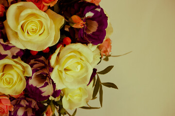 Background. Bouquet of flowers close-up on a white background illuminated by yellow, soft light. White and pink roses, blue-white eustoma. Place for text.