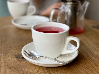 white cup with fruit tea on the table