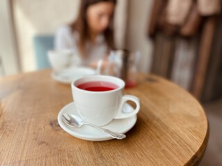 white cup with fruit tea on the table