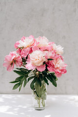 bouquet of pink peonies on a gray background with copy space. still life. womens day or wedding concept. festive background. Soft selective focus.